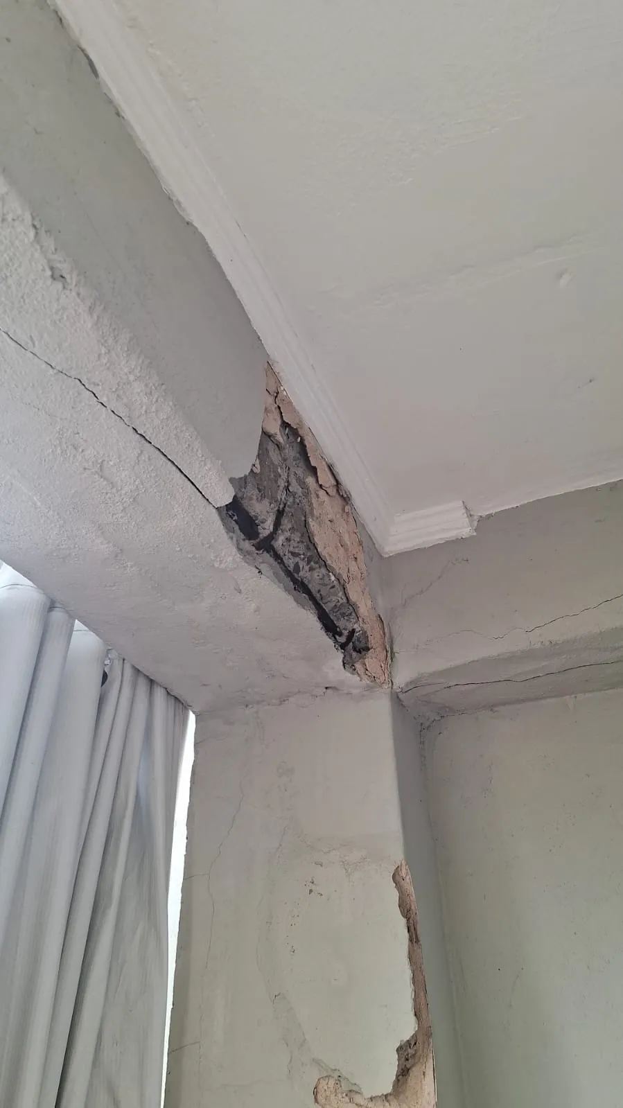 Detalhe aproximado de armadura de aço corroída e exposta em peça de concreto.